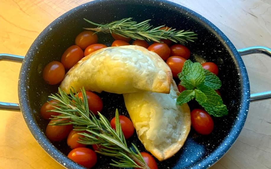 Freshly baked empanada with cherry tomatoes and rosemary